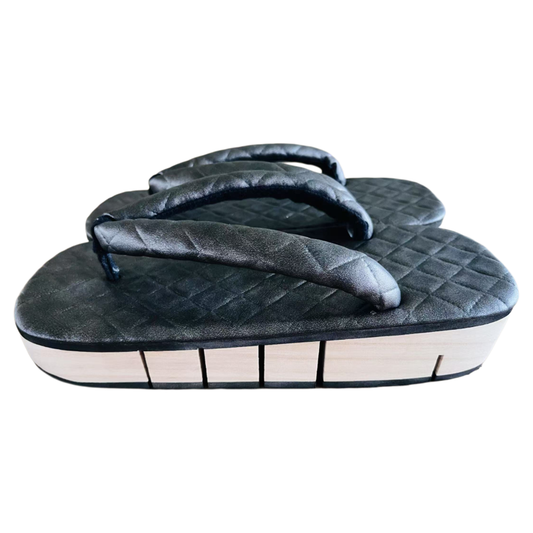 Black quilted sandal on a white background
