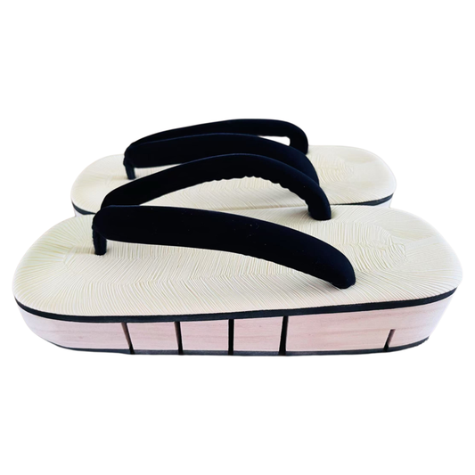 Pair of white sandals with black straps on a white background