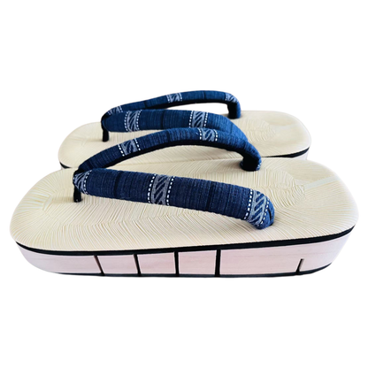 Pair of white sandals with blue straps on a white background