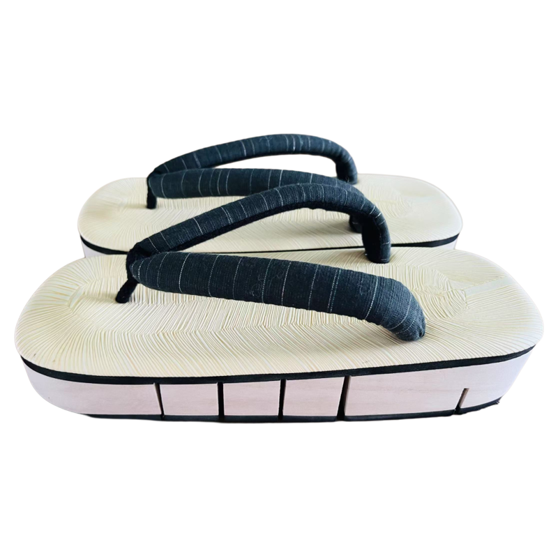Pair of traditional Japanese sandals with white soles and dark green straps on a white background