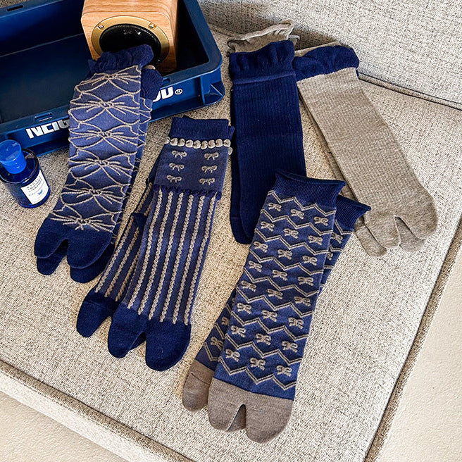 Pair of blue patterned socks with gray gloves on a textured surface